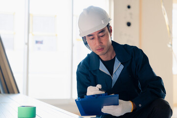 建設現場で資材の確認をする大工