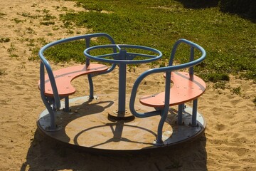 A carousel or merry-go-round in a playground on sand