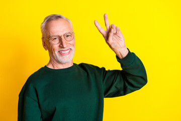 Photo portrait of handsome retired man show v-sign wear trendy green outfit isolated on yellow color background