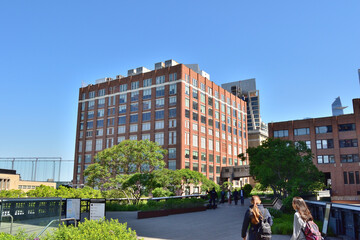 New York, USA - May 17 2023: A group of people walk on Hudson highs in front of a large brick...