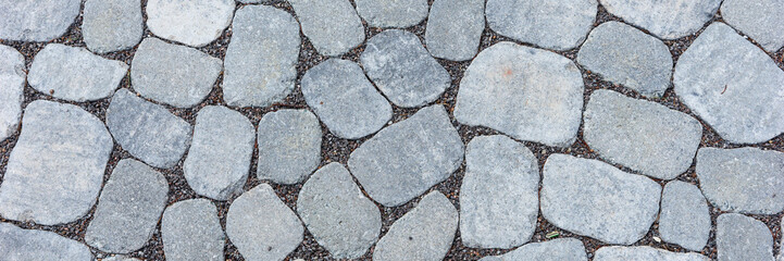 Panoramic image. New gray oval paving stones on the footpath