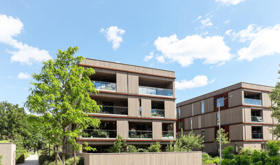 Residential area with ecological and sustainable green residential buildings, low-energy houses with wooden facade, timber construction and green courtyard