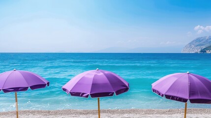 Fototapeta premium Purple beach umbrellas in a tranquil setting by the sea during summer holidays Beach umbrellas remain closed with few tourists around
