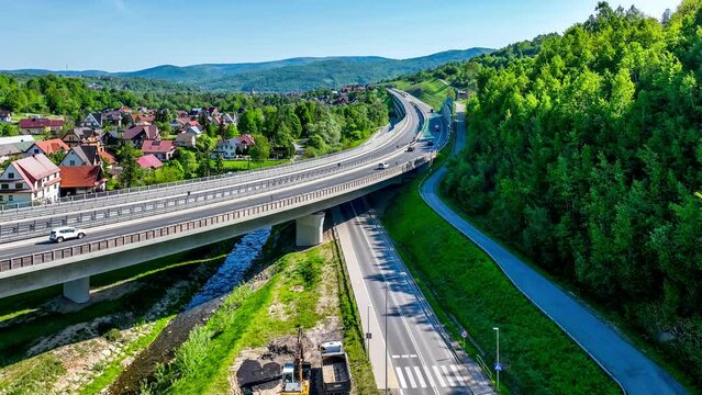 New elevated multilane highway and bend over old Zakopianka road in Lubien village in Poland, This motorway makes travel to Zakopane, Podhale region and Slovakia much faster. Aerial 4K video