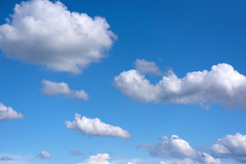 small soft cumulus fair weather clouds in a blue sky