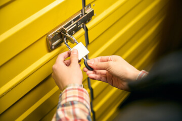 Tenant is padlocking steel self-storage unit door