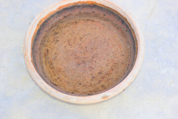 A close up shot of a wide mouth circular clay pot holding water.