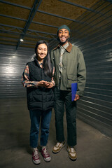Two people posing for camera in storage facility