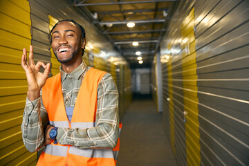 Joyous warehouse employee approving his workplace in front of camera
