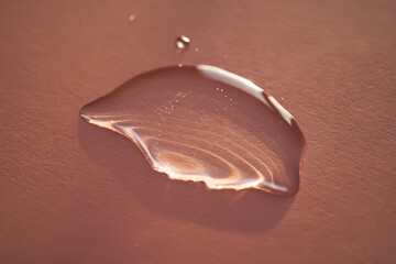 Beautiful volumetric drop of cosmetic product on a pink background.