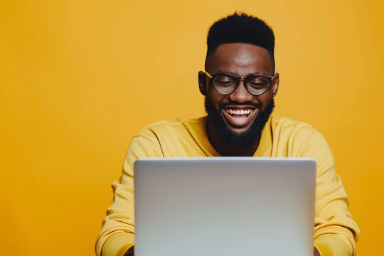 Cheerful African American man smiling at laptop isolated on a yellow background with copy space, Generative AI