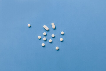 White pills scattered on a blue background.