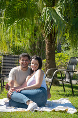 Família feliz sentada no jardim em dia ensolarada, Irmãos com suas esposa no jardim em meio a natureza, casal se divertindo em família