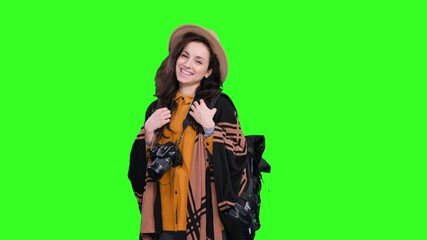 Smiling woman posing with backpack and camera during trip on the chroma key
