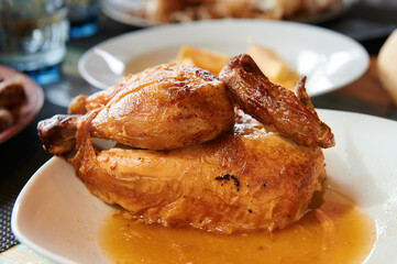 Roasted chicken sitting on top of a white plate.