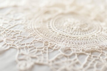 A close up of a white lace doily with a floral pattern