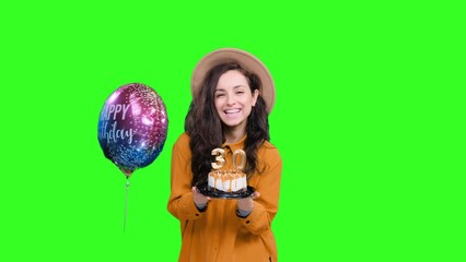 Smiling woman showing birthday cake with the number 13 on the chroma key