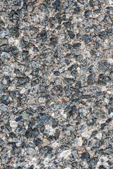 Texture of a wall made of small crushed stones of different color plastered with cement as a background