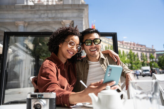 Multiethnic couple enjoying their time in Madrid, Spain, embracing and smiling