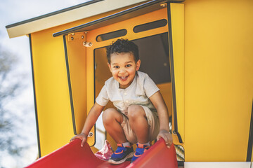 Happy kid slide on playground on summer season