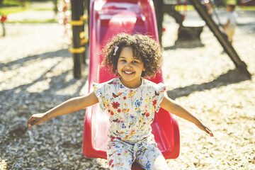 Happy kid slide on playground on summer season
