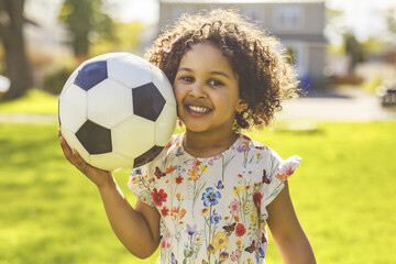 Sports kid. Happy little girl kid with a soccer ball, Child plays