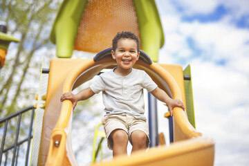 Happy 3 years old boy on a swing. Happy kid on playground