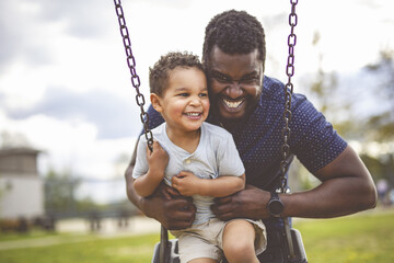 Playtime Moments. father With Her son Swinging Having Fun on the Playground Outside, Sharing Laughter and Joyful Bonding In Park Outdoors