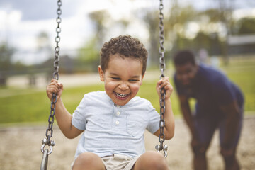 Playtime Moments. father With Her son Swinging Having Fun on the Playground Outside, Sharing Laughter and Joyful Bonding In Park Outdoors