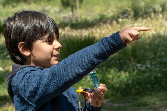 Young boy playing with a compass outdoors