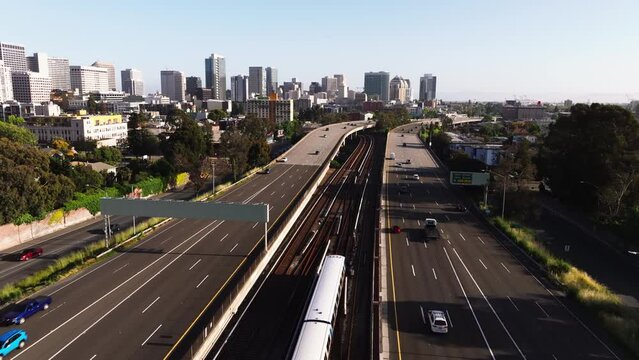 Air over freeway and houses towards skyscrapers in downtown Oakland, California