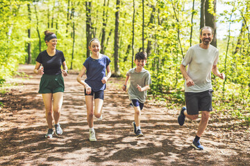 A Family exercising and jogging together at an outdoor park having great fun