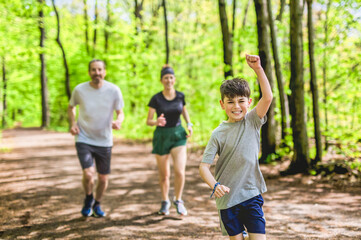 Naklejka premium A Family exercising and jogging together at an outdoor park having great fun