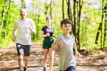 A Family exercising and jogging together at an outdoor park having great fun