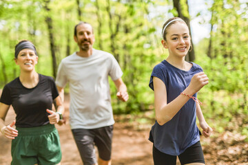 Obraz premium A Family exercising and jogging together at an outdoor park having great fun