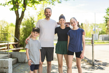 sporty Family posing together at an outdoor park having great fun