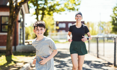 mother and son exercising and jogging together at an outdoor park having great fun