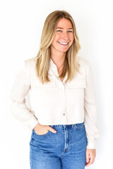 smiling blond girl with perfect teeth staring at camera, standing relaxed against white background