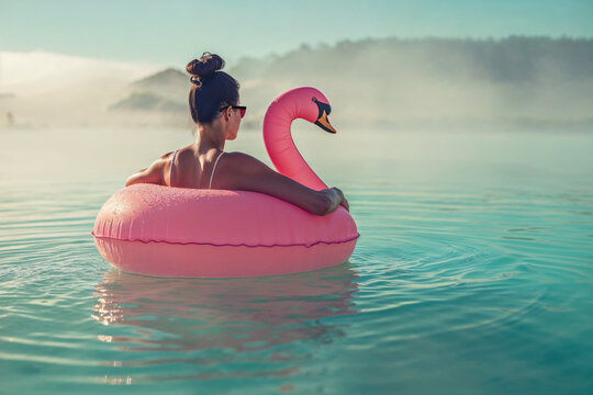 Woman on pink swan float at beach in summer morning. Generative AI