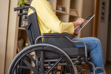 Person With Disability In A Wheelchair Enjoying Streaming Services At Home Using A Digital Tablet.