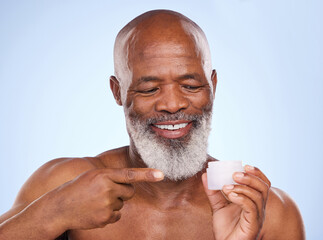 Beauty, cream and product with mature black man in studio on blue background for hydration or...