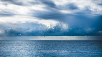 Stormy blue sky over the horizon of the ocean