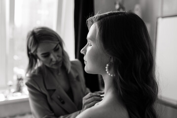 Backstage of the photo shoot: Make-up artist applies makeup on beautiful white model.
