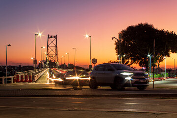 pôr-do-sol e  o tráfego intenso de carros   na ponte Hercílio Luz de Florianópolis, Santa...