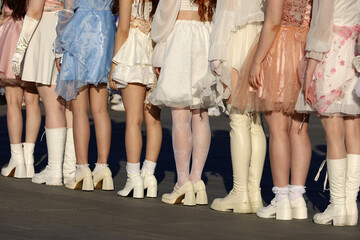 Girls wearing dresses and white socks and stockings standing on city street, female legs in white...