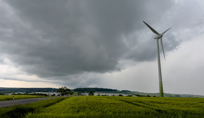 wind turbine in the field storm clouds over the road