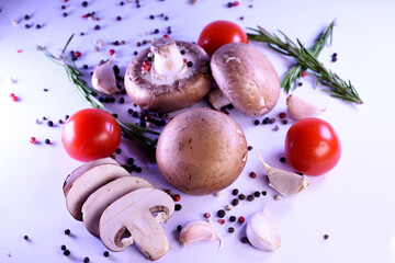 champignon mushrooms on a gray background with peppers and tomatoes. ingredients for a vegetarian dish