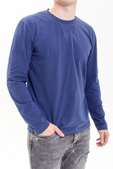 Young man in blue long sleeve shirt on white background. Sweatshirt and gray jeans