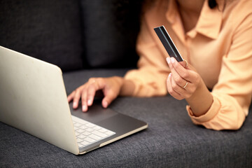 Home, laptop and woman with credit card, hands or savings with investment, typing or payment. Person, closeup or girl with pc, paying for goods and online shopping with ecommerce, banking or internet