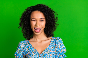 Photo of cheerful sweet lady blue top winking you eye empty space isolated green color background